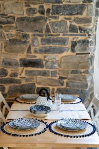 un tavolo in legno con piatti e un muro di pietra di Home Waves Como a Como