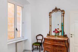 a mirror on top of a wooden dresser with a chair at San Francesco in Finale Ligure
