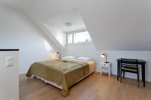 a white bedroom with a bed and a chair at Forenom Serviced Apartments Helsinki Kruununhaka in Helsinki