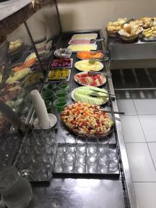 a buffet line with different types of food on plates at Hotel Pousada Alagoana in Maceió