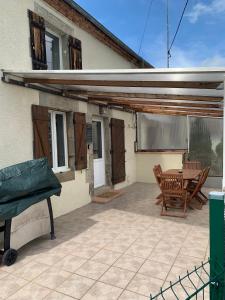 a patio with a table and chairs in front of a house at Swift Gites Creuse in Ventenat +12 photos