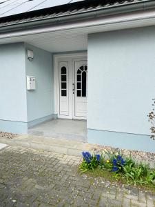 una casa blu con una porta bianca e fiori di Ferienwohnung Jahnke a Ostseebad Karlshagen