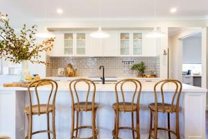 a kitchen with white cabinets and four chairs at a counter at River Run Bright in Bright