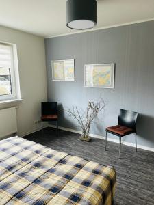 a bedroom with a bed and two chairs in it at Ferienwohnung Jahnke in Ostseebad Karlshagen