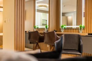 - une salle d'attente avec des chaises et des miroirs dans l'établissement Delupo Apart Hotel, à Criciúma