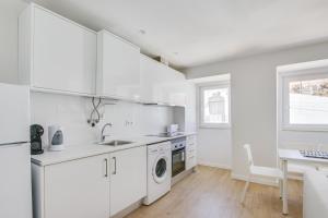 uma cozinha branca com um lavatório e uma máquina de lavar louça em Cruzeiro Charm Apartments em Lisboa