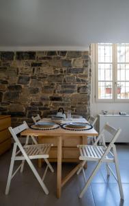 a table and chairs in a room with a brick wall at Home Waves Como in Como