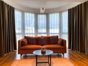 a living room with a brown couch and a table at Swiss Apartments Prishtina in Pristina