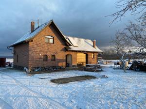 a brick house with snow on the ground at Penzion - Apartman Přestavlky in Tršice