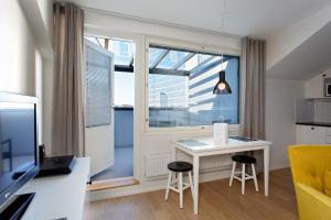 a small living room with a desk and a window at Forenom Serviced Apartments Helsinki Kruununhaka in Helsinki