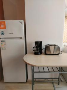 a kitchen with a table and a refrigerator at Bya Concept in Iaşi