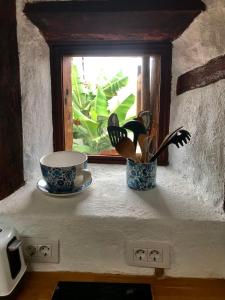 a window sill with two cups and a coffee mug at Casa Madera in Icod de los Vinos