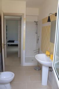 a bathroom with a toilet and a sink and a shower at Cilento Holiday Village in Montecorice