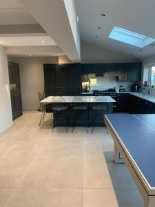a kitchen with black cabinets and a table and chairs at Welcoming Childwall Towers in Childwall