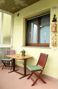 2 chaises, une table et une fenêtre sur une terrasse dans l'établissement Evergreen: tra mare e natura, à Cesenatico