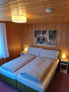 a bedroom with a bed with a picture of a bear at Hotel Tell in Seelisberg