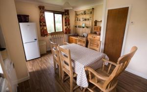 a kitchen with a table and chairs and a refrigerator at Allt Slapin in Torrin