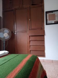 1 dormitorio con 1 cama y armarios de madera en Córdoba - La Cumbre -Casa Temporario -Vista Cristo en La Cumbre