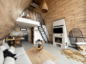 a living room with a couch and a fireplace at By The Lake - A Frame in Căciulaţi
