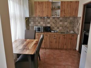 - une cuisine avec une table en bois et un four micro-ondes dans l'établissement APARTAMENT REGUN, à Reghin