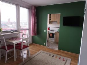 a green room with a table and a kitchen with a stove at City Studio in Częstochowa