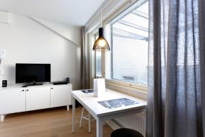 a white room with a desk and a window at Forenom Serviced Apartments Helsinki Kruununhaka in Helsinki