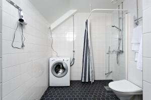 a bathroom with a washing machine and a toilet at Forenom Serviced Apartments Helsinki Kruununhaka in Helsinki