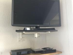 a flat screen tv on a shelf with two video game consoles at Vue mer, crique de Peyrefite, Cerbère-Banyuls. in Cerbère