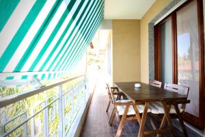 einen Balkon mit einem Holztisch und Stühlen in der Unterkunft Mediterraneo in Bordighera