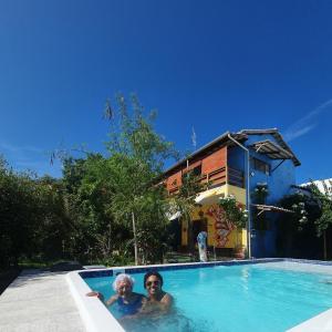 duas pessoas na piscina de uma casa em Quintal da Espera - Praia de Itacimirim em Camaçari