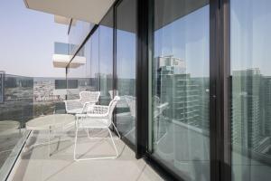 a balcony with chairs and a table on a building at Revelton Apartment One Residence in Dubai