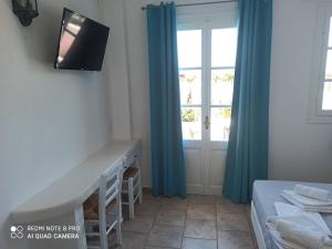 a bedroom with a desk and a window at Almyra Seaside Suites in Platis Gialos
