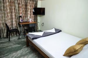 a bedroom with a bed and a desk in a room at NALINAM HOMESTAY in Trivandrum