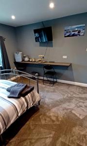 sypialnia z łóżkiem, biurkiem i telewizorem w obiekcie Large double room with spacious ensuite w mieście Southbourne