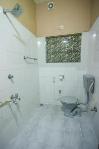 y baño con aseo y ducha. en NALINAM HOMESTAY en Thiruvananthapuram