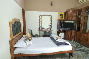 a bedroom with a bed with a mirror and a tv at NALINAM HOMESTAY in Trivandrum