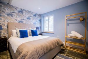 a bedroom with blue walls and a bed with blue pillows at Sleepers Barn in Saint Teath