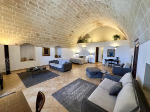 ein Wohnzimmer mit Sofas und Ziegelwand in der Unterkunft Masseria Torre Spagnola in Matera