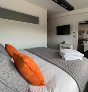 a bedroom with an orange pillow on a bed at Withers Farm Apartments in Mount Bures