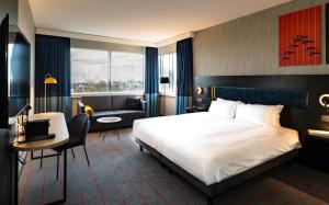 a hotel room with a large bed and a living room at Mercure Antwerp City South in Antwerp