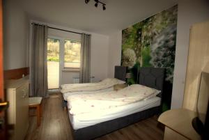 two beds in a room with a large window at Kosciuszko Apartment in Muszyna