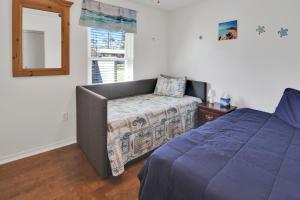 Schlafzimmer mit einem Bett und einem Spiegel in der Unterkunft Jewell Cottage in Port Saint Joe