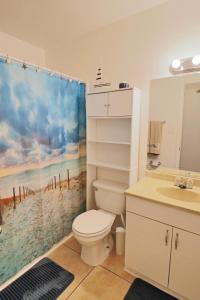 ein Badezimmer mit einem WC, einem Waschbecken und einem Duschvorhang in der Unterkunft Jewell Cottage in Port Saint Joe