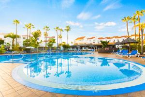 een groot zwembad in een resort met palmbomen bij Wyndham Residences Golf del Sur in San Miguel de Abona