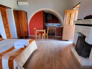 a room with a bed and a kitchen with a fireplace at Lithochtisto in Monemvasia