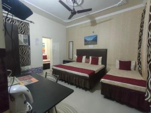 a hotel room with two beds and a table at New Chandigarh Holiday Home in Chandīgarh