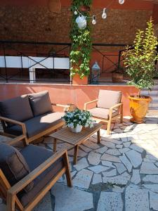 un patio con 2 sillas, una mesa y un sofá en Aux Berges du Canal, en Capestang