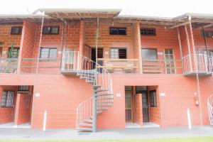 Un edificio de ladrillo con escaleras a un lado. en Martim de Sá - Caragua, en Caraguatatuba