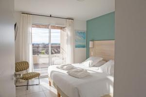 um quarto com uma cama e uma janela com vista em Résidence Pierre & Vacances Premium Horizon Golf em Saint-Cyprien