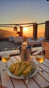 un piatto di cibo su un tavolo con due bicchieri da vino di Mykonos Pro-care Suites ad Áno Merá